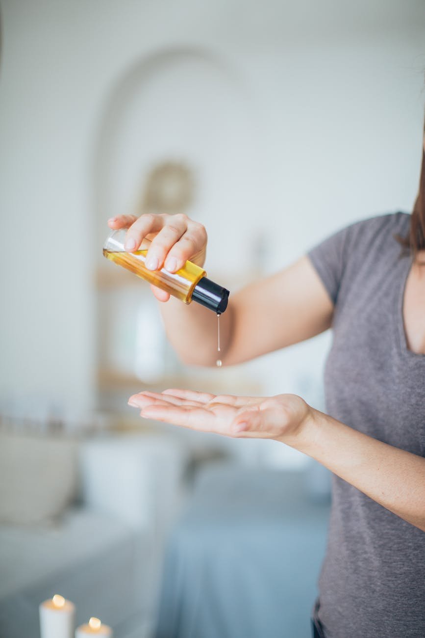 a person pouring a massage oil on it s hand